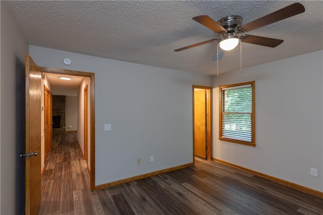 unfurnished room featuring dark wood-style flooring, baseboards, a ceiling fan, and a textured ceiling