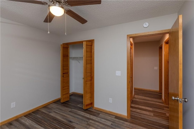 unfurnished bedroom with dark wood-style flooring, a closet, baseboards, a textured ceiling, and ceiling fan
