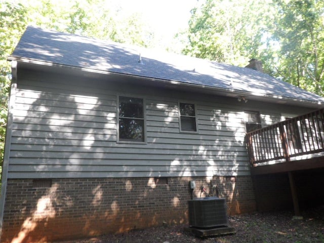 124 S Spring St, Central, SC 29630 - view of side of property featuring a deck, a chimney, brick siding, and roof with shingles