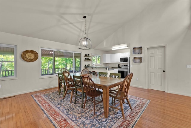 451 Cedar Creek Rd, Sunset, SC 29685 - dining area with light wood-style floors, baseboards, high vaulted ceiling, and a chandelier
