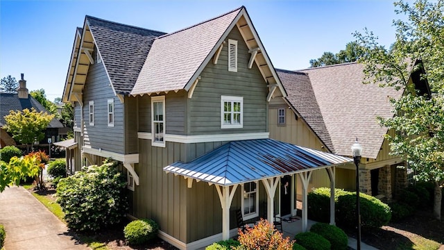 view of front facade with a shingled roof and board and batten siding