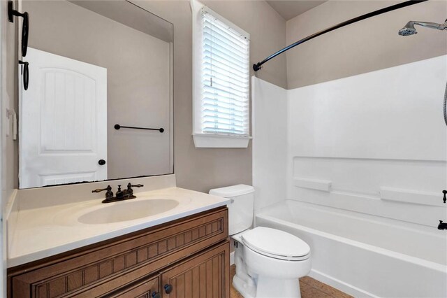 bathroom with toilet, vanity, and  shower combination