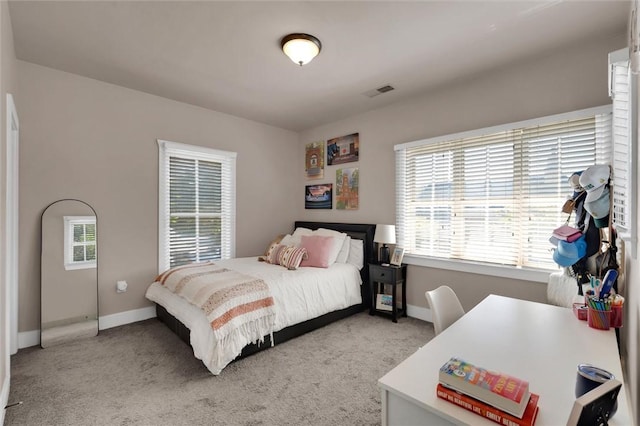 bedroom featuring light colored carpet and baseboards