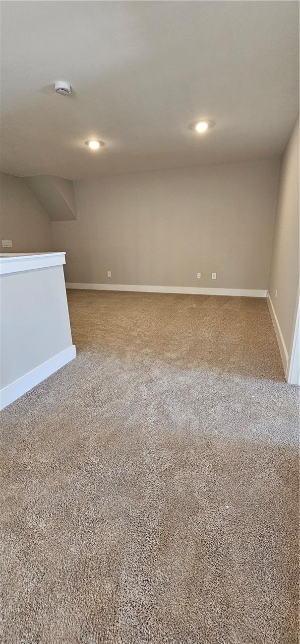 empty room featuring carpet, baseboards, recessed lighting, and a smoke detector