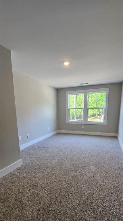 empty room with baseboards, carpet, and recessed lighting