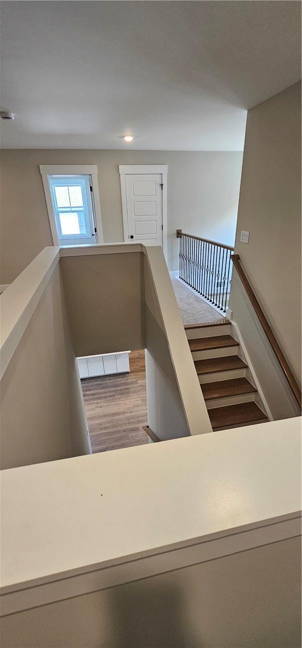 staircase with wood finished floors and recessed lighting