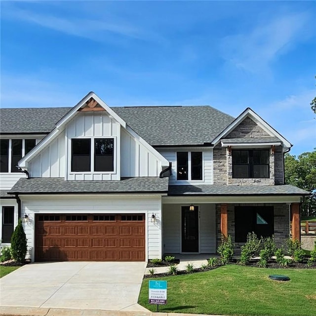 modern farmhouse style home with board and batten siding, covered porch, a front yard, a garage, and driveway