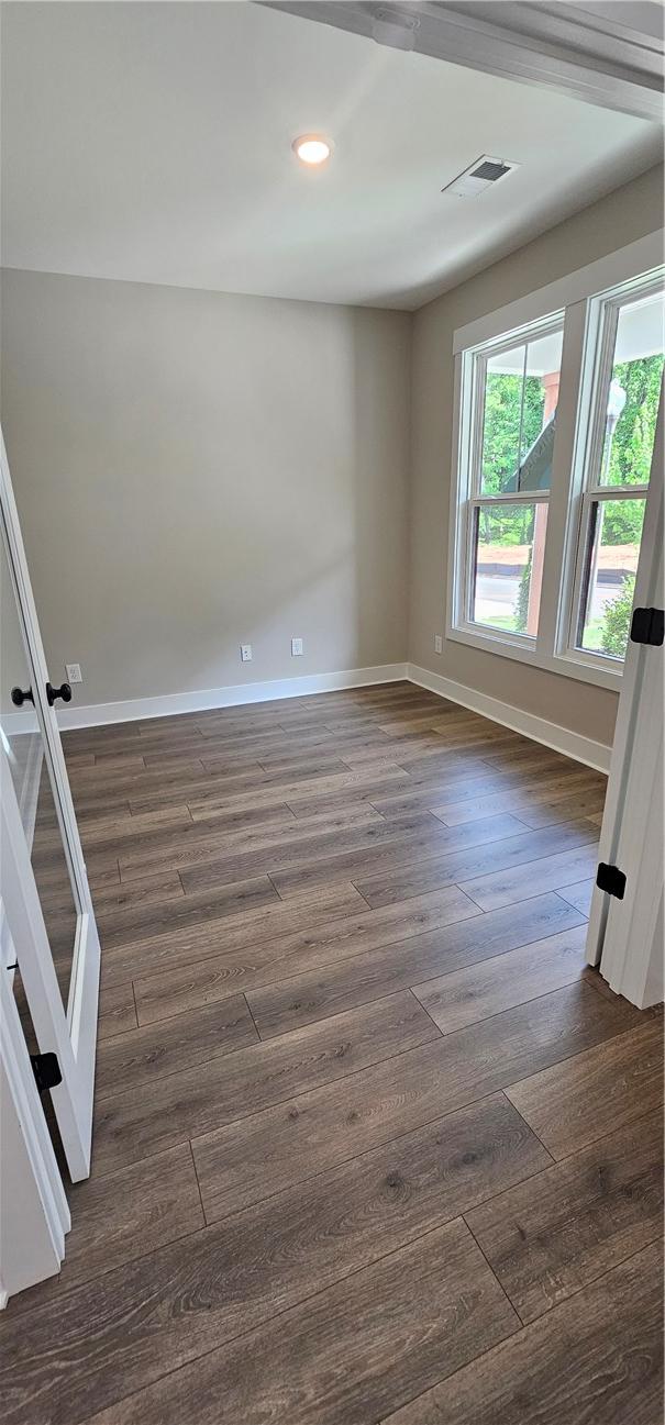 unfurnished room featuring baseboards, dark wood-style floors, and recessed lighting