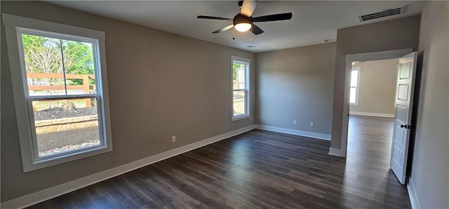 unfurnished room featuring baseboards, dark wood-style floors, and a ceiling fan