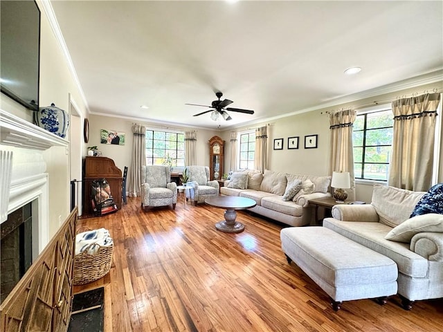 living room featuring a fireplace, ornamental molding, hardwood / wood-style floors, a ceiling fan, and recessed lighting