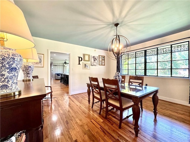 dining room with a chandelier, wood finished floors, and baseboards