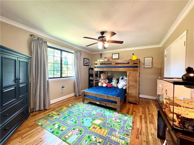 bedroom featuring ornamental molding, light wood-style flooring, baseboards, and a ceiling fan