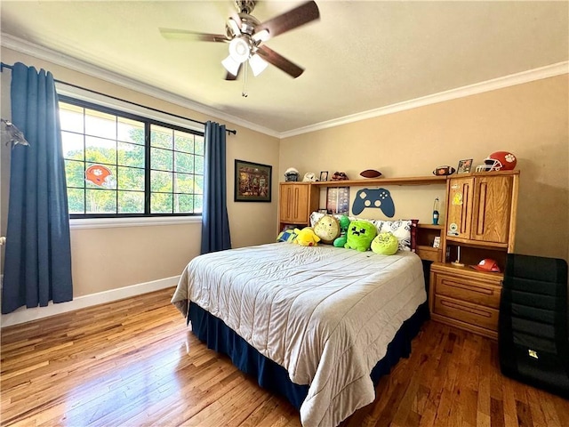 bedroom featuring wood-type flooring, ornamental molding, baseboards, and ceiling fan