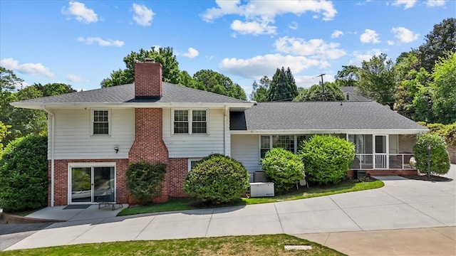 224 Sheffield Rd, Greer, SC 29651 - view of front facade with a chimney, brick siding, a patio area, a sunroom, and roof with shingles