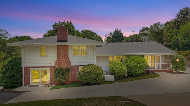 224 Sheffield Rd, Greer, SC 29651 - view of front of house with a chimney, brick siding, a patio area, and a sunroom
