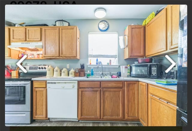 kitchen featuring dishwasher, under cabinet range hood, black microwave, stainless steel electric stove, and a sink