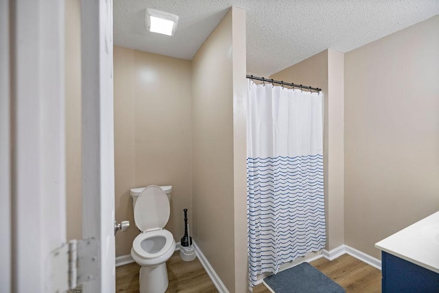 111 Coachman Ct, Anderson, SC 29625 - bathroom with wood finished floors, toilet, baseboards, a shower with shower curtain, and a textured ceiling