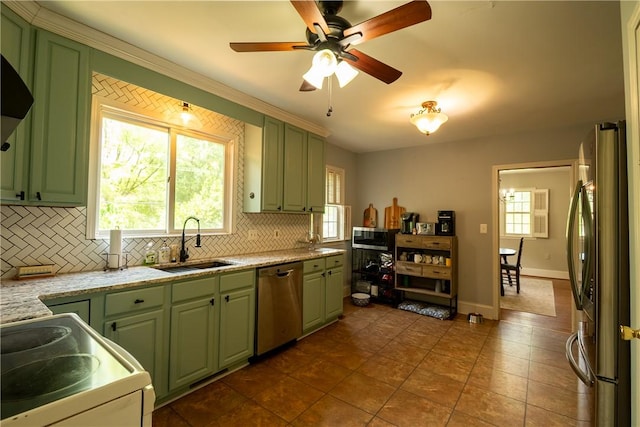 kitchen with green cabinets, appliances with stainless steel finishes, a sink, and backsplash