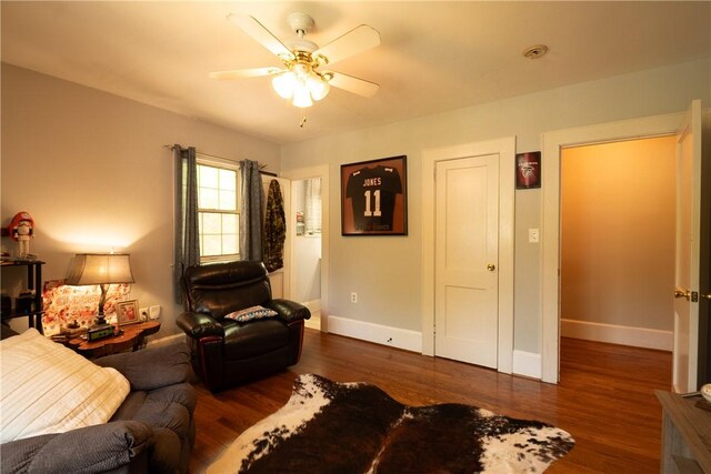 living room with wood finished floors, ceiling fan, and baseboards