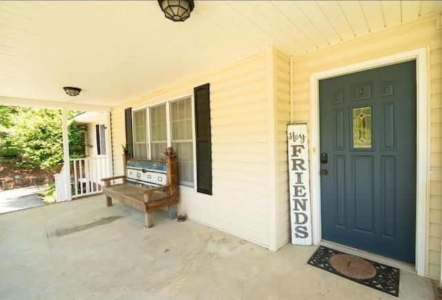 view of exterior entry featuring covered porch