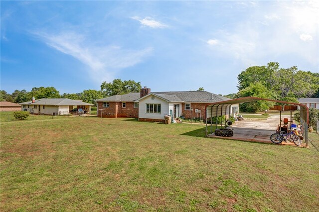 203 Greenmeadow Cir, Anderson, SC 29626 - back of property with a carport, a yard, a chimney, and brick siding