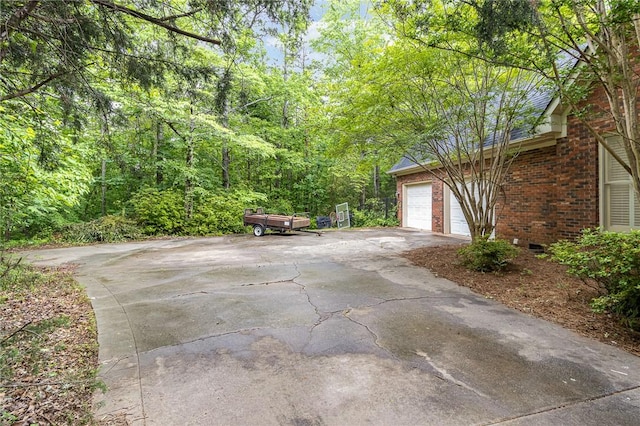 503 Columbine Ct, Easley, SC 29642 - view of patio featuring a garage, asphalt driveway, and a wooded view