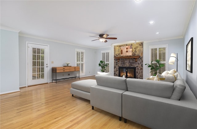 503 Columbine Ct, Easley, SC 29642 - living room with crown molding, light wood-style flooring, ceiling fan, a stone fireplace, and baseboards