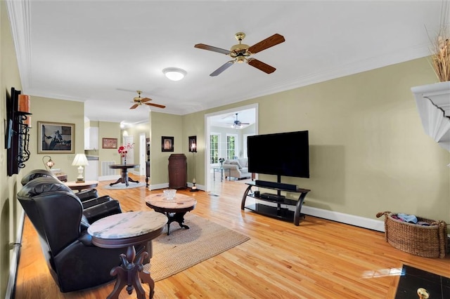 living area featuring a ceiling fan, wood finished floors, ornamental molding, and baseboards