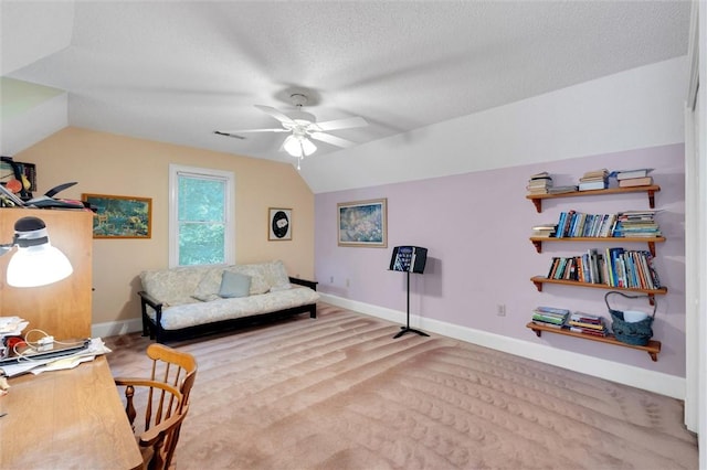 living area with vaulted ceiling, a ceiling fan, baseboards, and a textured ceiling