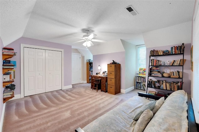 carpeted office featuring lofted ceiling, a ceiling fan, baseboards, and a textured ceiling