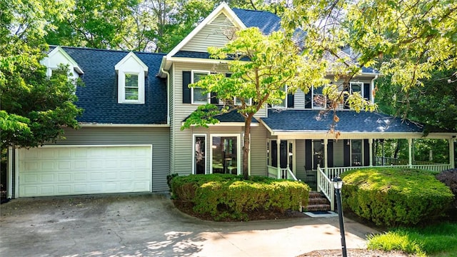 view of front facade with a garage, concrete driveway, and roof with shingles