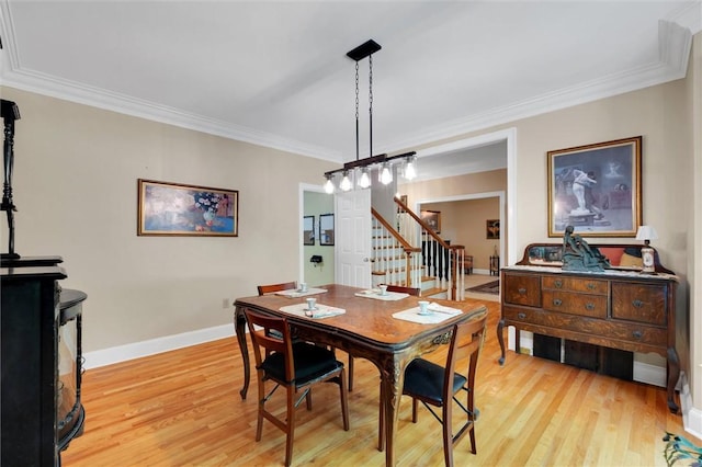 dining space with light wood-style floors, stairway, baseboards, and ornamental molding