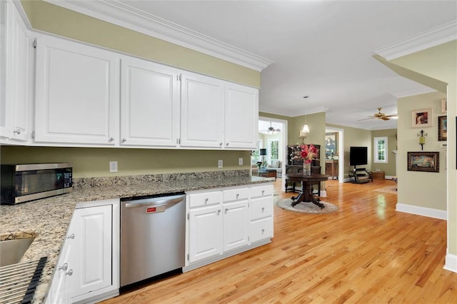 kitchen with appliances with stainless steel finishes, a ceiling fan, ornamental molding, and white cabinets