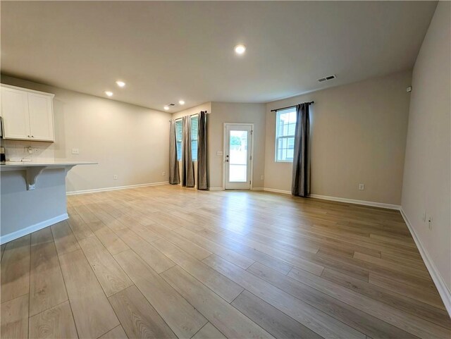 unfurnished living room featuring light wood-style floors, baseboards, and recessed lighting
