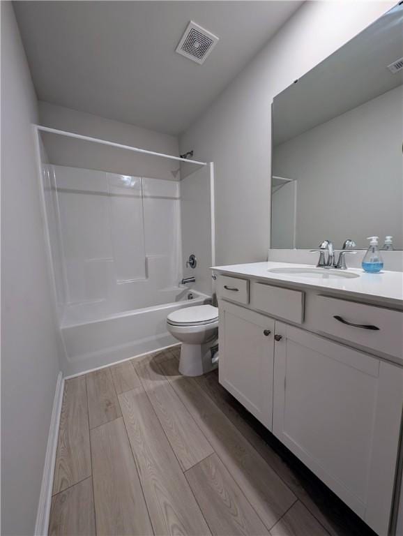 full bathroom with toilet, wood finished floors, vanity, and bathing tub / shower combination