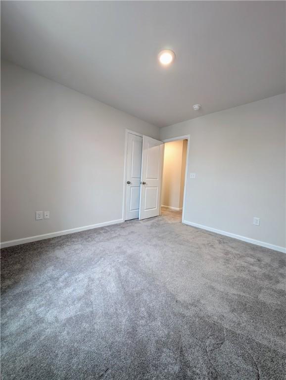 unfurnished bedroom with baseboards and carpet