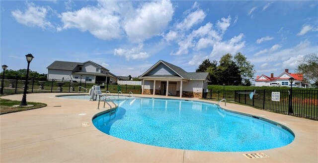 community pool featuring fence and a patio