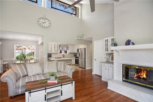32 Par Harbor Way, Salem, SC 29676 - living area with a towering ceiling, dark wood-style floors, a glass covered fireplace, a ceiling fan, and baseboards