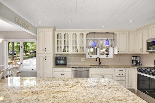 32 Par Harbor Way, Salem, SC 29676 - kitchen with a sink, appliances with stainless steel finishes, cream cabinets, glass insert cabinets, and backsplash
