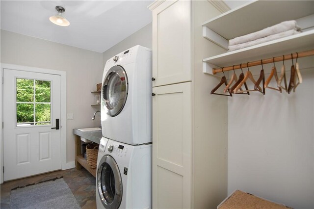224 Edgewood Dr, Seneca, SC 29678 - washroom featuring stacked washer and clothes dryer, cabinet space, and dark stone finish floors