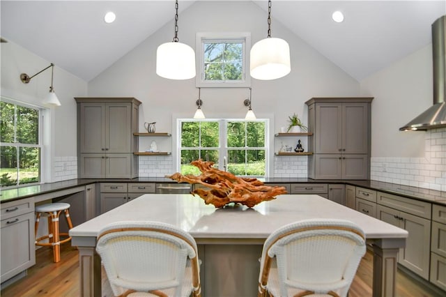 224 Edgewood Dr, Seneca, SC 29678 - kitchen with open shelves, wall chimney exhaust hood, high vaulted ceiling, decorative backsplash, and light wood-style flooring