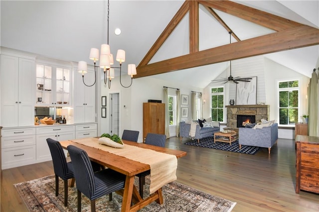 224 Edgewood Dr, Seneca, SC 29678 - dining space featuring wood finished floors, a fireplace, a chandelier, high vaulted ceiling, and ceiling fan