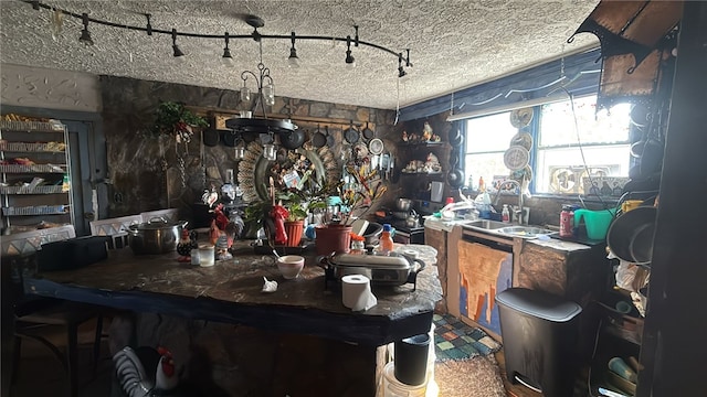 kitchen with a sink, track lighting, and a textured ceiling