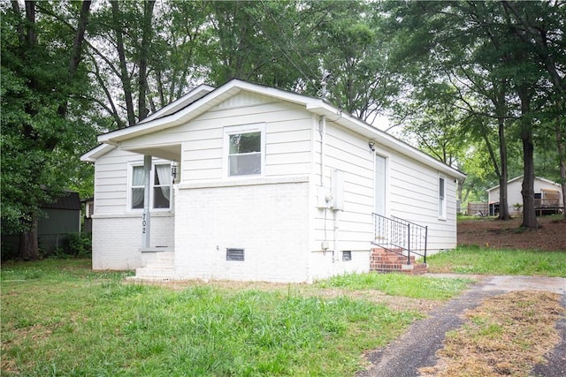 view of home's exterior featuring crawl space, a yard, and brick siding