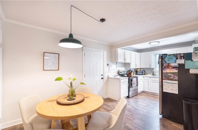 dining space featuring ornamental molding, wood finished floors, and baseboards