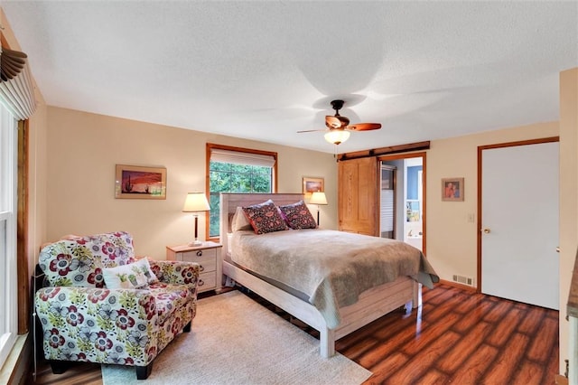 220 Family Dr, Seneca, SC 29678 - bedroom featuring wood finished floors, a barn door, ceiling fan, and a textured ceiling