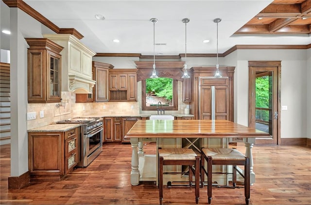 503 Greystoke Cv, Seneca, SC 29678 - kitchen with high end range, a sink, wood finished floors, brown cabinets, and crown molding