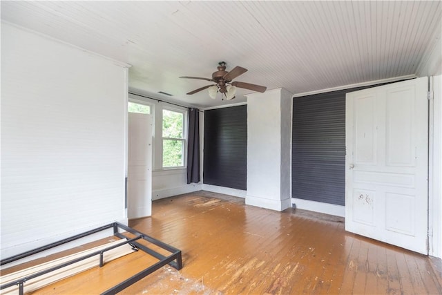 empty room with ceiling fan, wood-type flooring, and baseboards