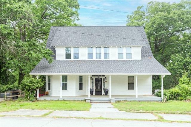 country-style home featuring a shingled roof, a porch, and a front lawn