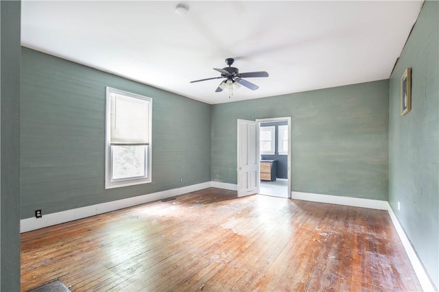 spare room with hardwood / wood-style floors, ceiling fan, baseboards, and a smoke detector